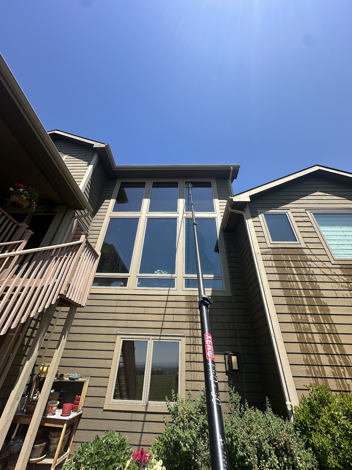 Water-fed pole reaching tall two-story windows on a Billings home