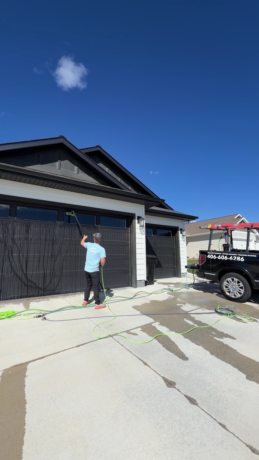 Scrub Squad technician cleaning garage windows with the branded truck parked nearby